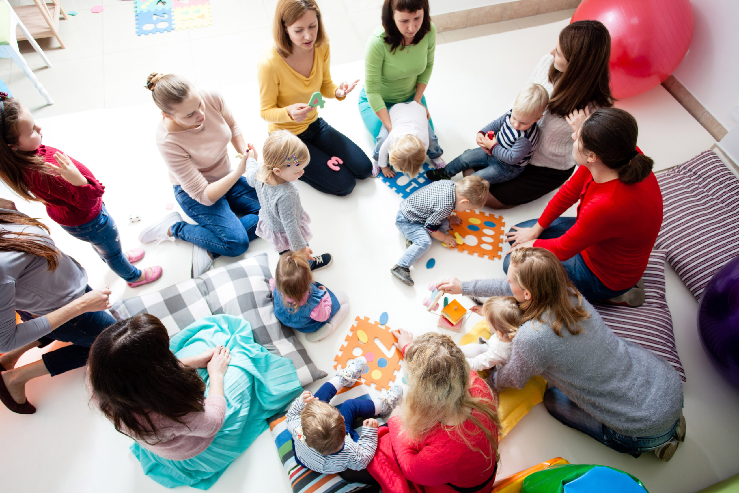 Young moms sitting in a circle with their kids